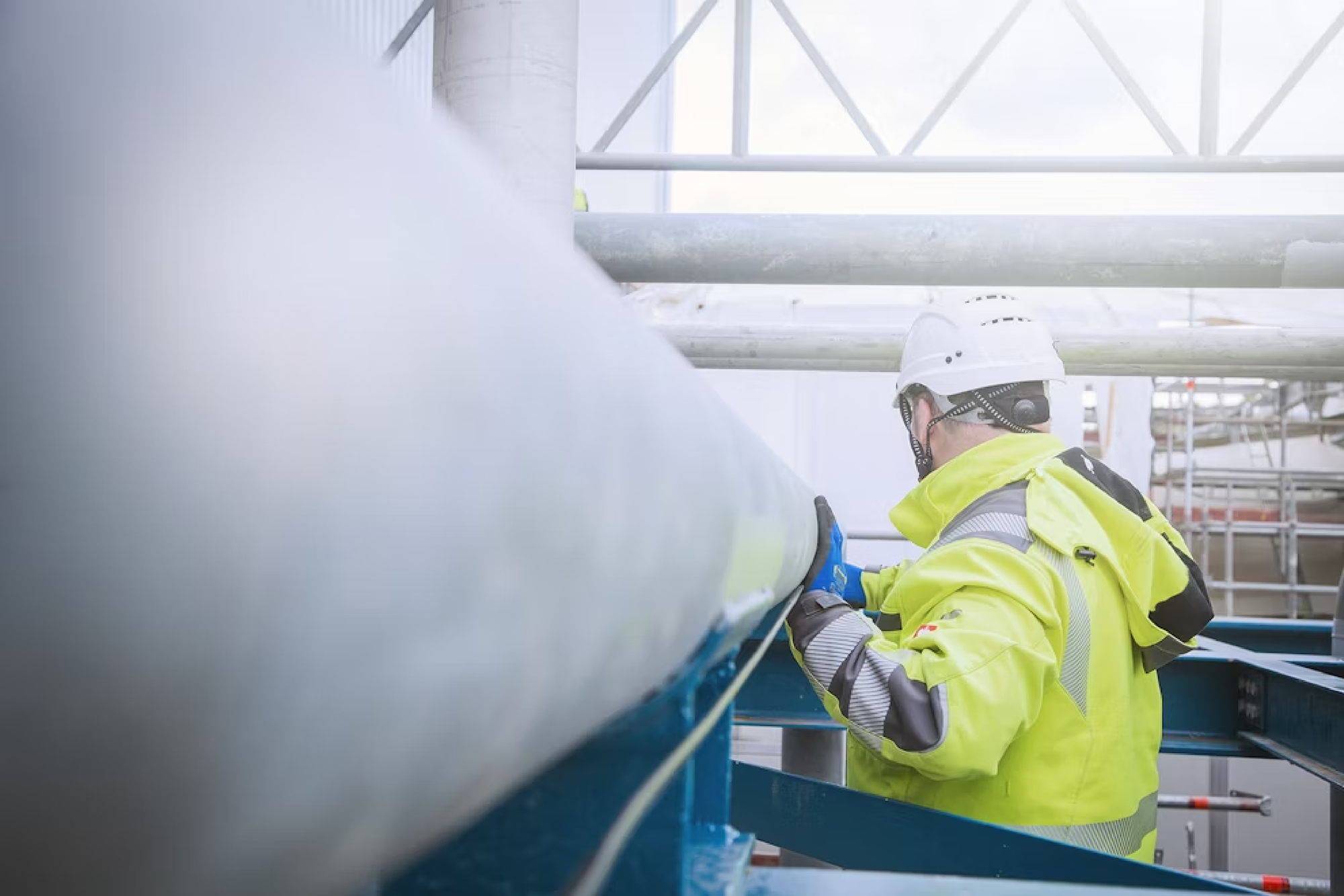 Ein Mann befestigt ein Kabel an ein Rohr