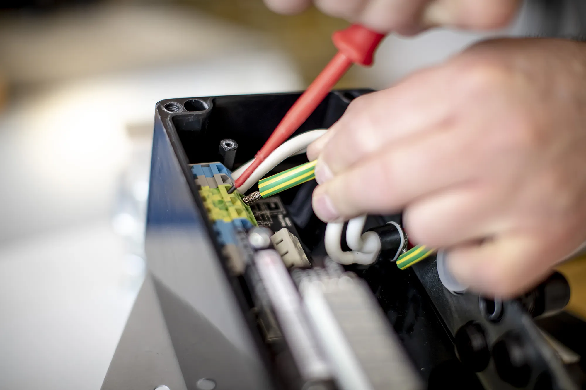 Ein Mann bastelt an einem Gestell, in das Kabel eingebunden sind